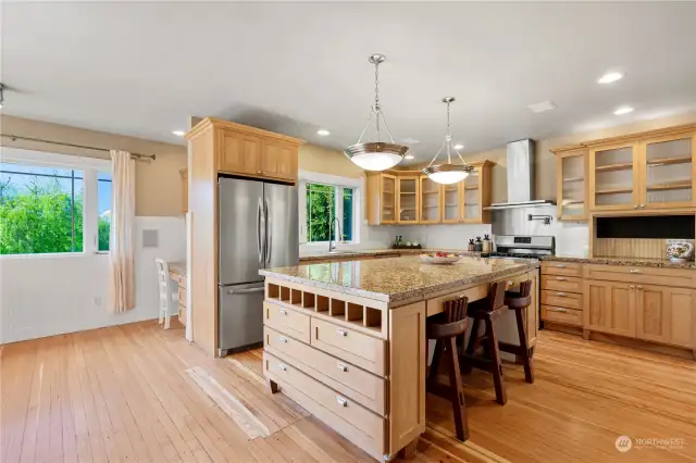 Massive kitchen Island with granite countertops and stainless-steel appliances.