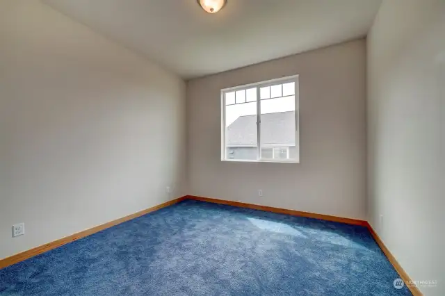 One of two spacious bedrooms with large windows.