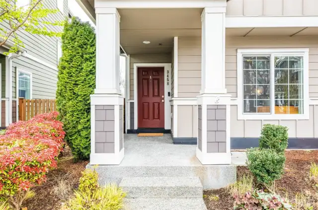Hello curb appeal! Covered front porch with mature landscaping greets you and your guests!