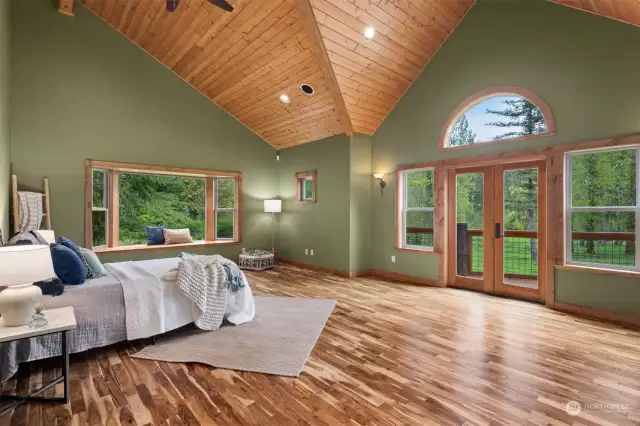 The primary bedroom suite in so spacious and has the gorgeous acacia wood floors.  There is a window seat that looks out to Ten mile creek and the ponds and it opens onto the wraparound deck.