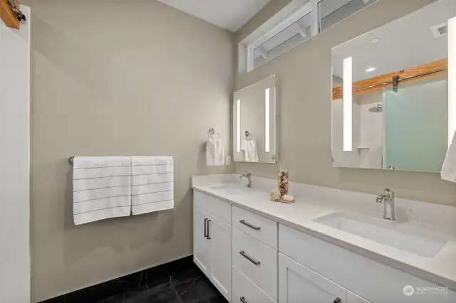 the primary bath is cozy with heated floors, accessible shower and LED mirrors.