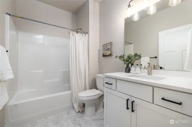 The main bath has taller cabinets, comfort height toilet & quartz counters