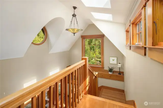 Windows and skylights brighten the staircase area, showcasing Craftsman light fixtures and the eyebrow window.