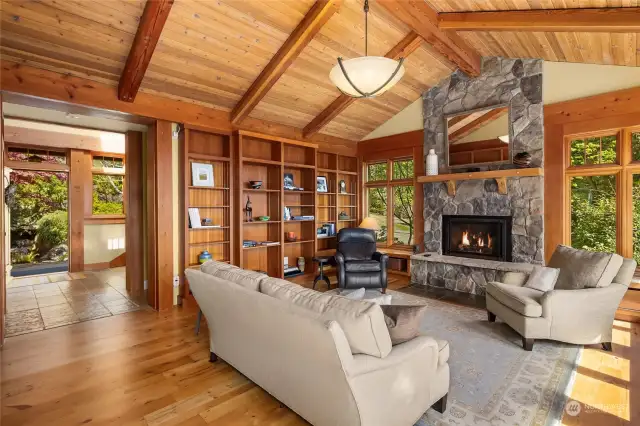 The living room is anchored by an imposing natural stone fireplace, an inviting space for intimate gatherings.
