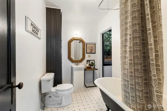Bathroom has built in storage, and a vintage clawfoot tub with shower.