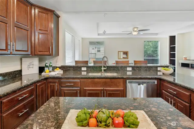 Luxurious granite countertops grace the kitchen, providing a durable and elegant surface for cooking and dining, complemented by a central island for additional workspace.