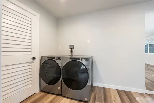 Laundry area with door to furnace room and lots of additional storage space.