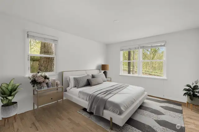This northwest facing primary bedroom enjoys serene afternoon light and cooler evenings, providing a peaceful and comfortable sanctuary
