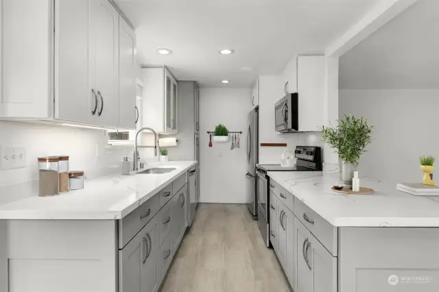This luminous kitchen features modern countertops, ample cabinet space, and sleek stainless steel appliances