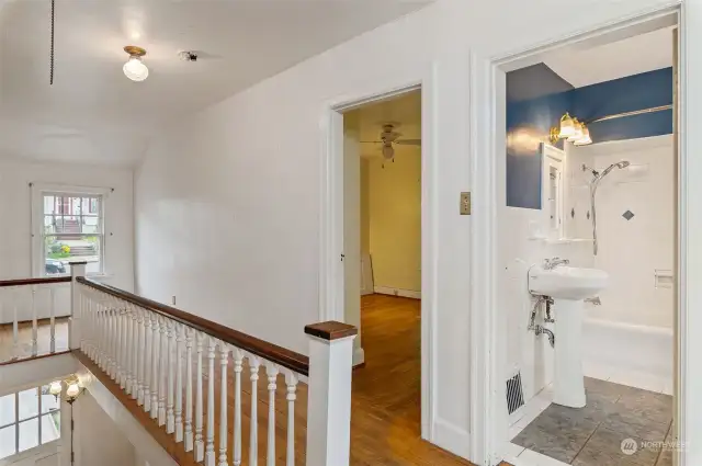 Upstairs hallway with full bath and original laundry shoot.