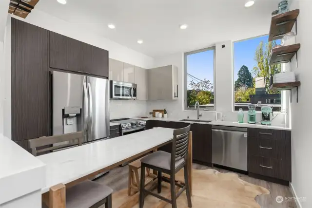 Spacious kitchen with high end stainless steel appliances, all custom shelving stays. Enjoy daytime sunshine and create your own herb garden on the window sill!