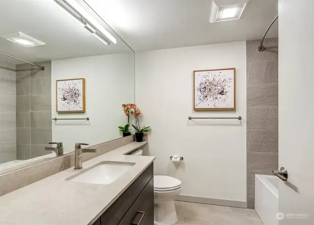 The updated hall bath has lots of counter space and a tub with beautiful tile surround.