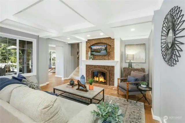 Open, great-room layout with wide plank hardwood floors. Gas fireplace with insert, coffered ceiling and French doors eading to the resort-style garden.