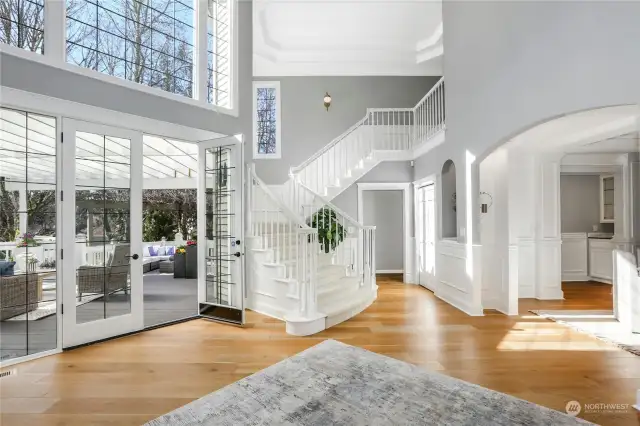 Dramatic, curving staircase with sconce lighting and exquisite custom millwork & ceiling treatments.  Impressive, designer lighting and architectural niches surprise and delight throughout this light-filled floorplan.