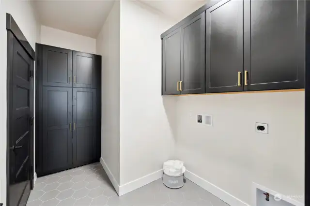 Main level laundry room with pantry and additional storage.