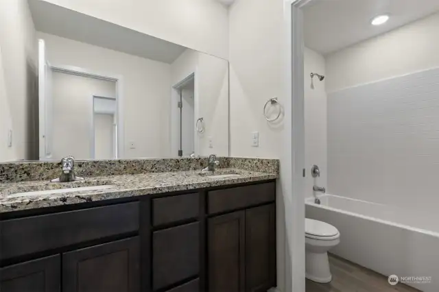 Full bathroom with dual sink serves the three bedrooms at this side of the home.