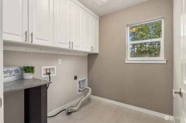 Convenient upstairs Laundry Room with custom California Closet cabinets (2021).  Speed Queen  White Washer & Dryer are in garage and will remain.