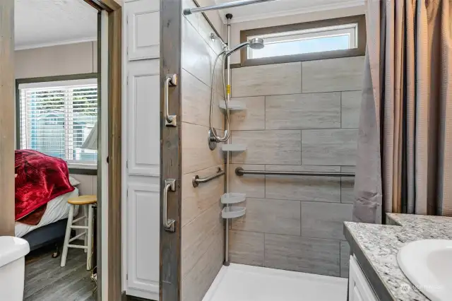 Tiled/remodeled 3/4 bathroom with ample linen/towel storage