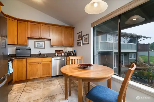 Eat in kitchen features updated cabinetry, granite counter top, newer stainless appliances and tile floor.