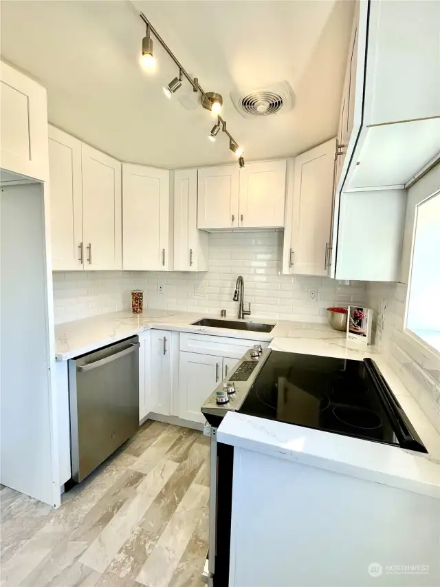 Bright, Fully-Remodeled, Modern Kitchen w/New: Paint, Cabinets, Quartz Counters, Tile Backsplash, Flooring, Lighting, Dishwasher, Large Stainless Sink/Faucet, Electric Oven/Stove w/window to deck and backyard - Day