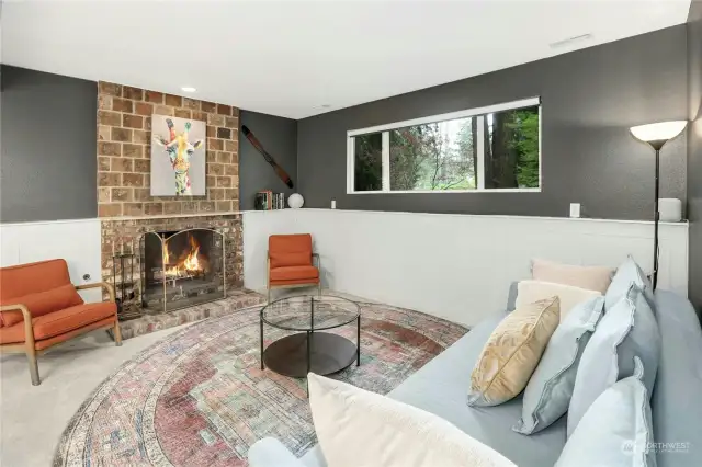 The family room with handsome brick fireplace, and white panel molding.