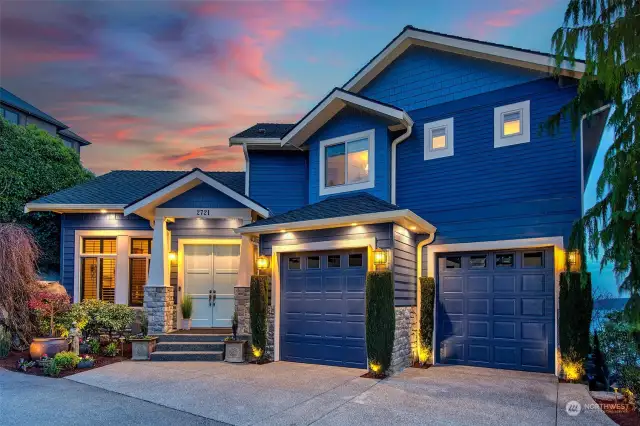 Front of home, showing off the evening sunsets.  The home has great accent lighting outside with landscape lighting.  Two car garage is fully equipped with built-in storage, new paint, new garage floor system and electric car charger.