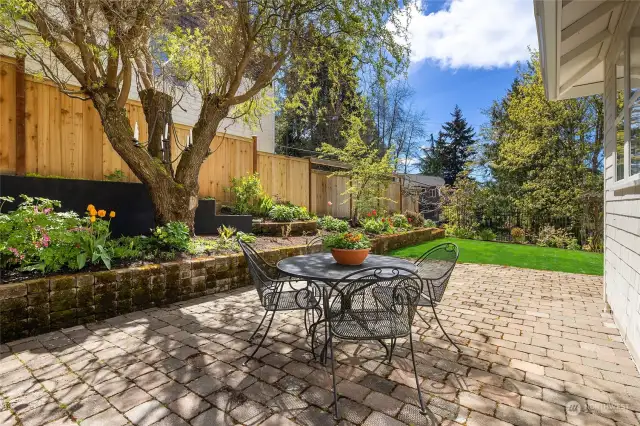 Sunny and private cobblestone paver patio, fully fenced yard with western-exposure, and lovely perennial gardens