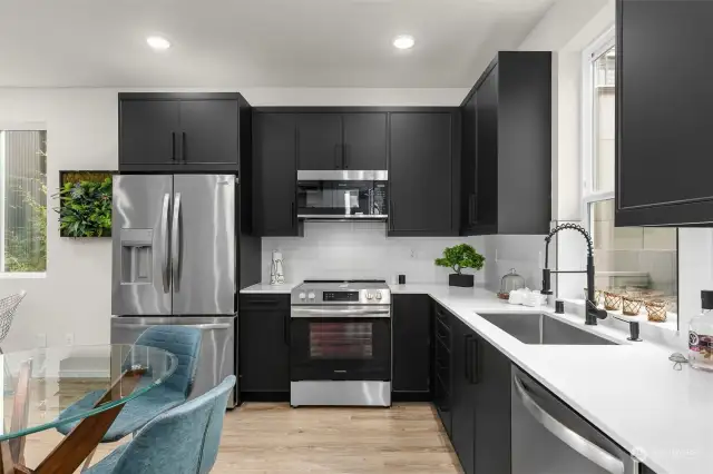 Your sleek chef's kitchen boasts black custom cabinetry, stainless steel appliance package and premium black hardware package.