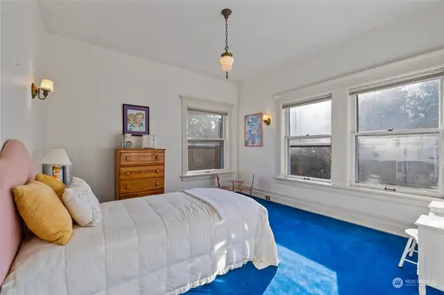The fifth bedroom is light and bright with windows facing south and east, and original lighting fixtures.