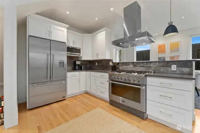 Handsome DCS stainless appliances grace this immaculate kitchen, accompanied by dark grey quartz coutnertops.