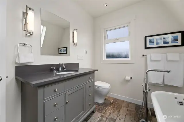 The upper level bathroom is bright and spacious and home to a stately, refinished clawfoot tub.