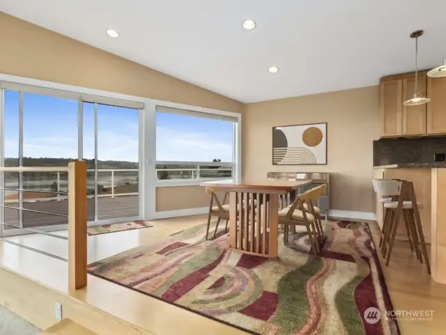 Dining area with amazing westward views, kitchen with eating space visible just behind.