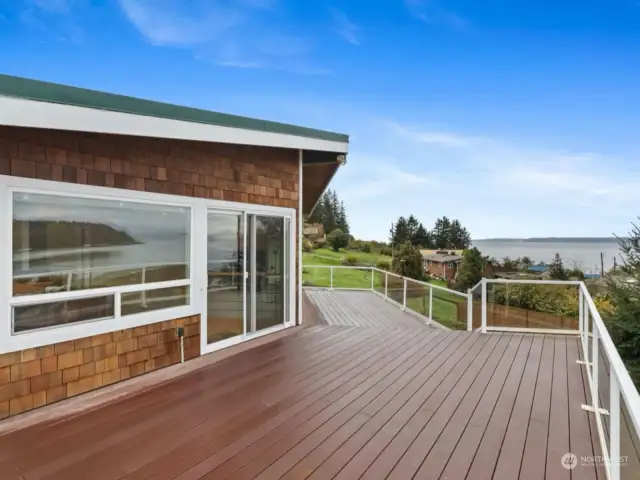 View from giant trex deck looking into slider door to dining area, and showcasing the stunning views this home offers daily.