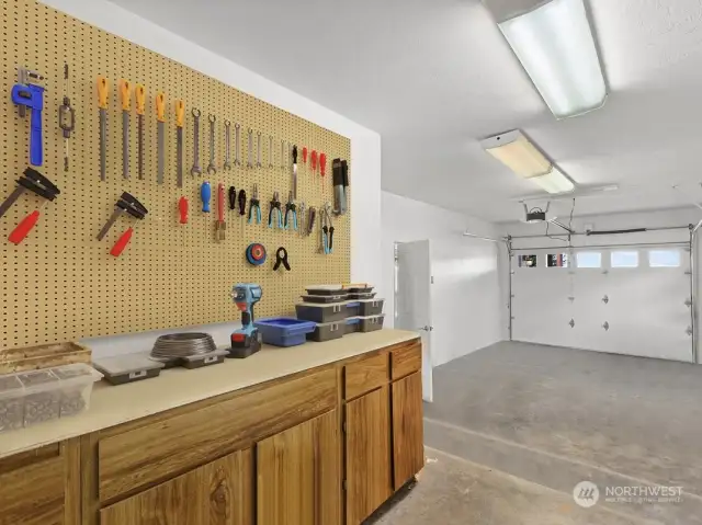 Raised area at rear of garage complete with cabinets & pegboard to help keep tools organized. Home wired for generator as well.