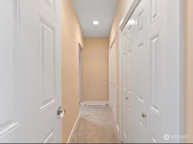 Doorway into primary, large walk-in-closet space length of right entry wall.