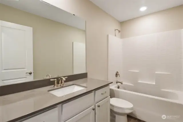 Primary bathroom featuring shower & bathtub and spacious sink.