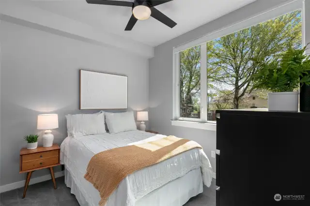 Main level bedroom complete with a ceiling fan and carpet flooring, ideal for a study or guests!