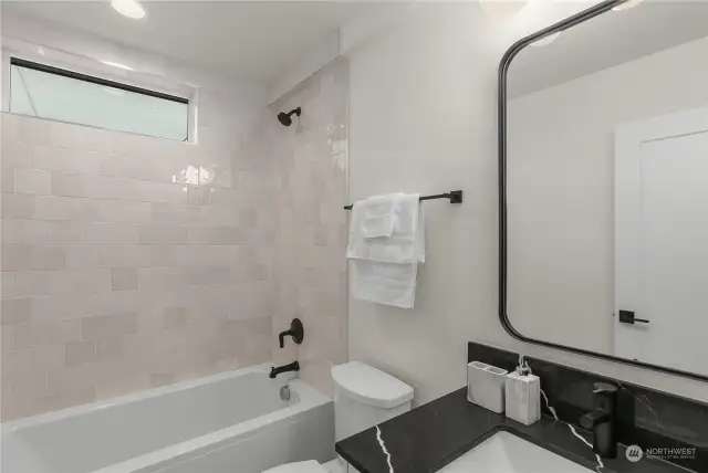 The elegant guest bathroom provides a full bathtub with custom built-in vanity.
