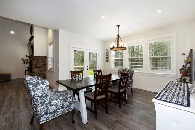 Spacious dining ~ wagon wheel lighting adds an element of warmth ~ plantation blinds ~ French Doors ~ Beautiful floors ~  setting the stage for unforgettable memories!