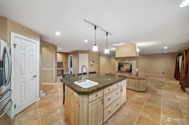 OPEN kitchen- knotty pine cabinets, ceramic floor tiles, two sided fireplace into family room, TWO walk-in pantries and an island veggie sink!