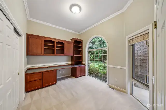 Formal office located by the front door- floor to ceiling windows, closet, crown molding & build in cherry desk.