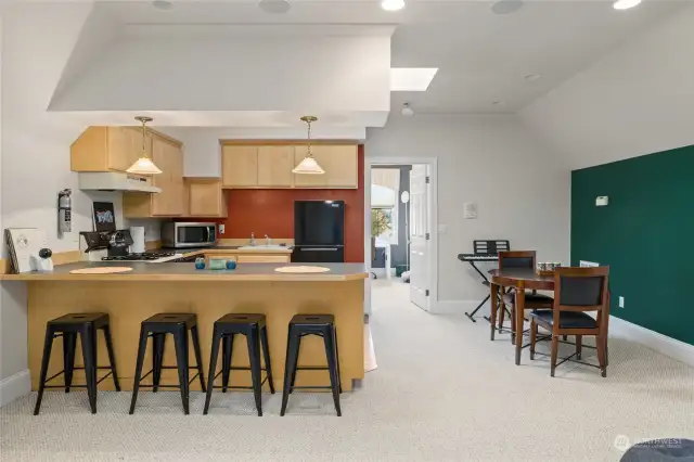 Apartment kitchen with eating bar and dining space.