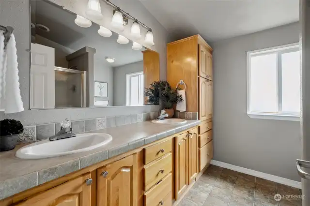 Primary bathroom with double sinks and a walk in shower plus plenty of storage.