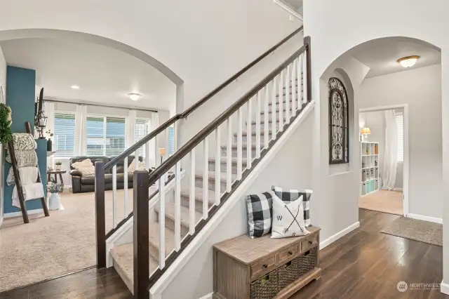 A generous entry with art niche, beautiful staircase, & easy care laminate floors.