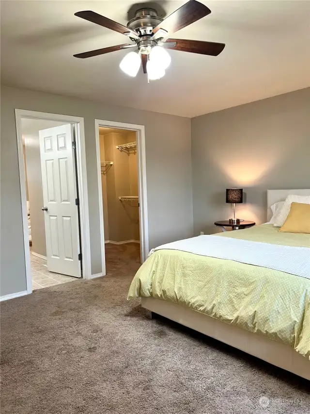 A large primary bedroom with a five piece jetted bathtub and walk-in closet.