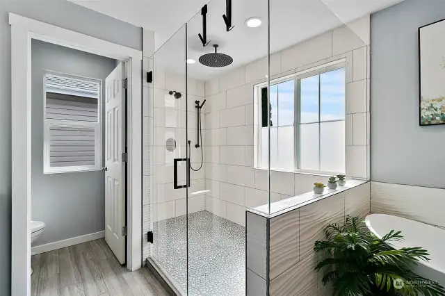 This shower is huge with glass surround and door and lots of light from the large, yet private windows.