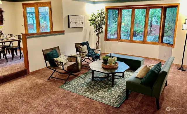 The sunken living room with beautiful wood wrapped, leaded & beveled bay windows has a lovely view of the private backyard.