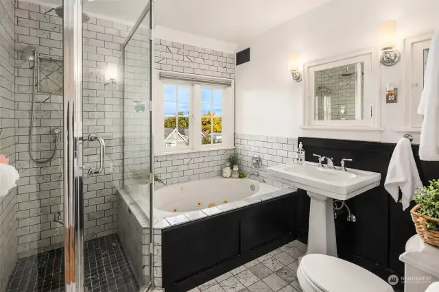 This bathroom has marble tile and a jetted tub.