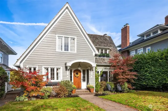 I love the arch over the doorway, the rounded door, the windows, and the shed dormer. A ten out of ten in curb appeal!
