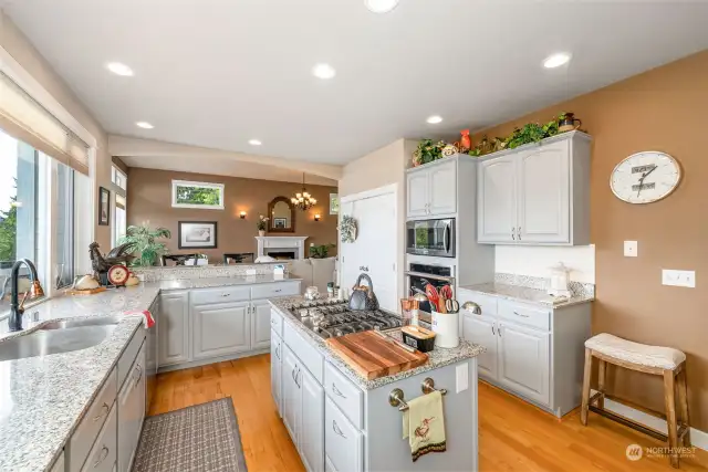 The chef's kitchen has expansive granite countertops, gas range, plenty of cabinets, and a large pantry. Look at those cabinets, so much storage!